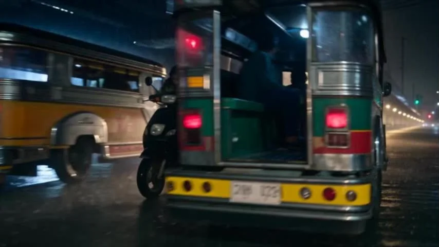 Lia on her scooter squeezing behind a jeepney in the rain